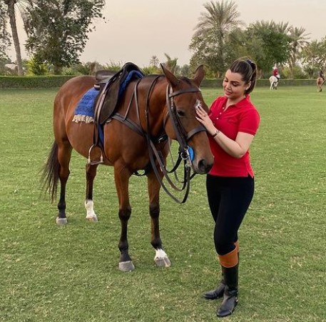 Kyra Dutt posing with a horse