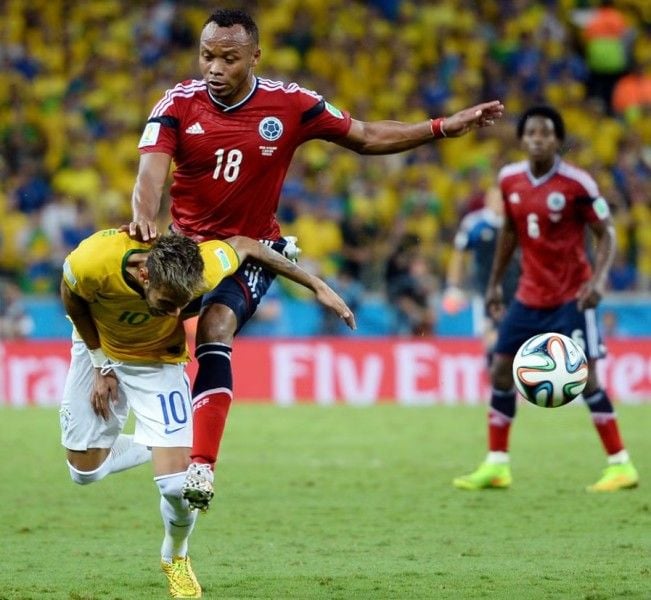 Neymar (in yellow) with Juan Zuniga (on his back) which ruled him out of the 2014 FIFA World Cup
