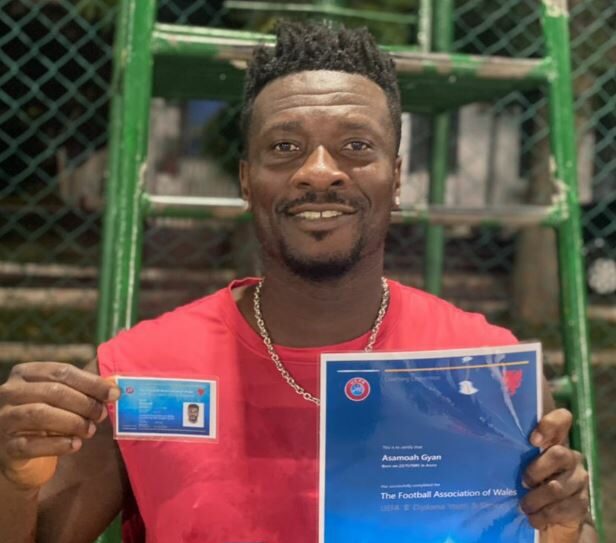 Asamoah Gyan showing his coaching licence