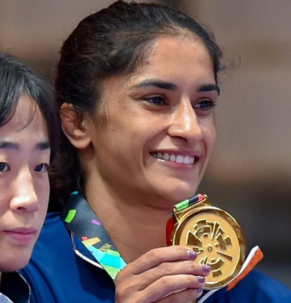 Vinesh Phogat shows off her gold medal from the podium after the medal ceremony for the 50 kg category wrestling competition at the Asian Games 2018