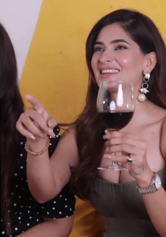 Karishma Sharma holding a glass of wine