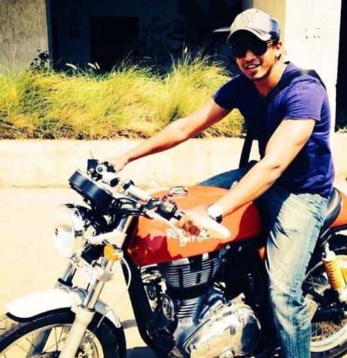 Abhijeet Sawant sitting on his Royal Enfield motorcycle