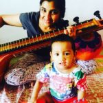 Syamala playing the guitar along with her son