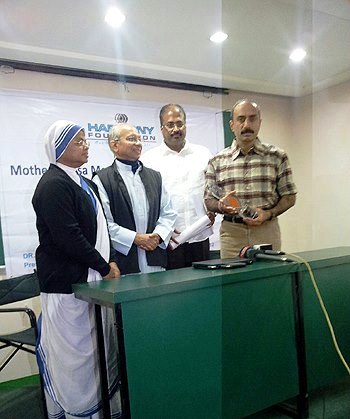 Sanjiv Bhatt standing with his Mother Teresa Memorial International Award during the award presentation ceremony