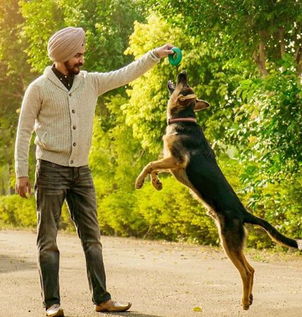 Supneet Singh playing with a dog