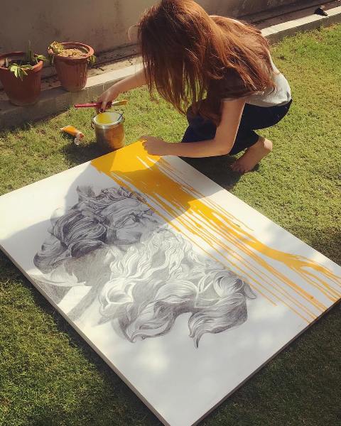 Naimal Khawar painting a canvas