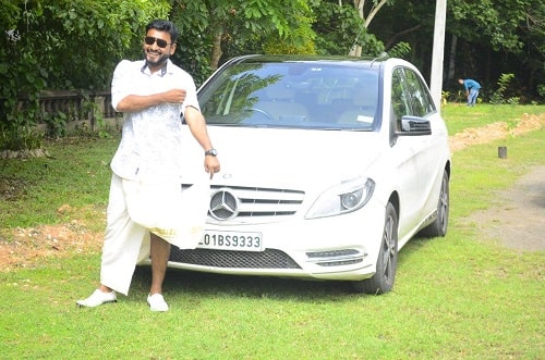 Firoz Azeez posing with his Mercedes car