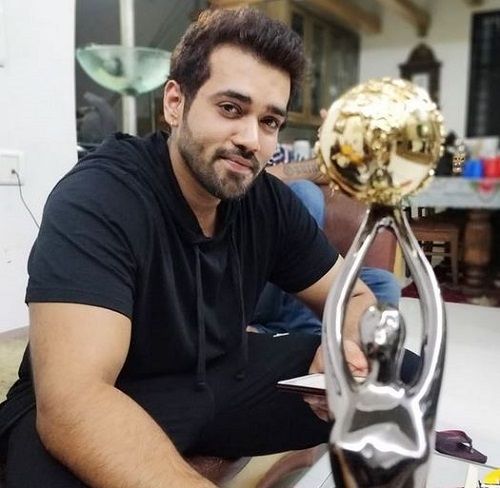 Karan Khanna posing with his award
