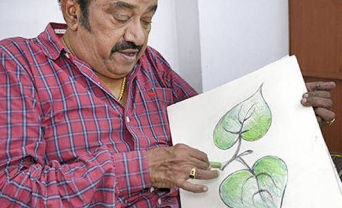 Pandu showing the Two Leaves logo he designed for MGR