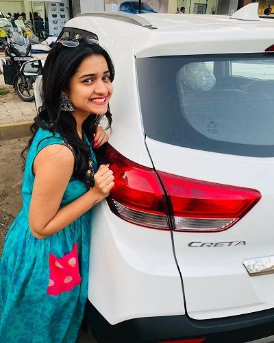 Hruta Durgule posing with her car