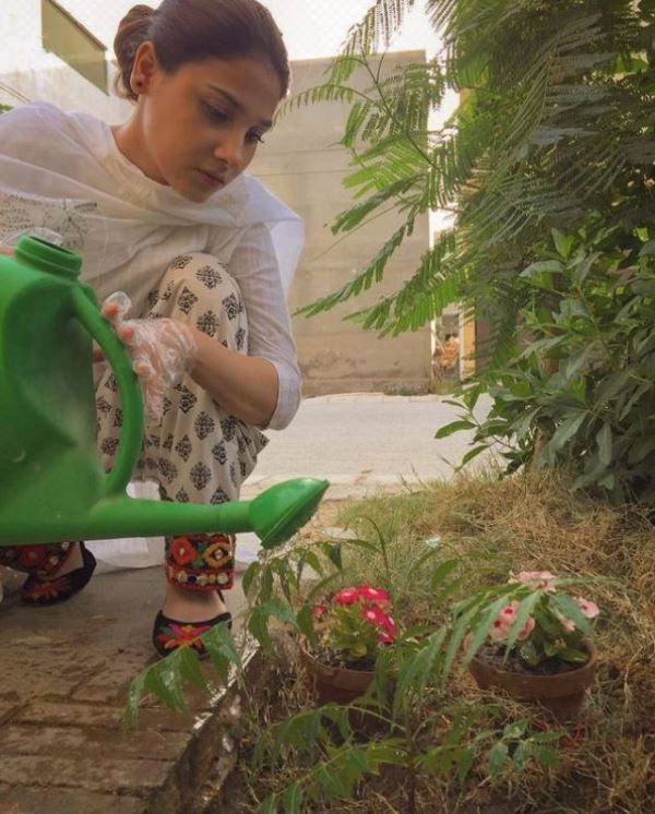 Hina Altaf watering plants in her garden