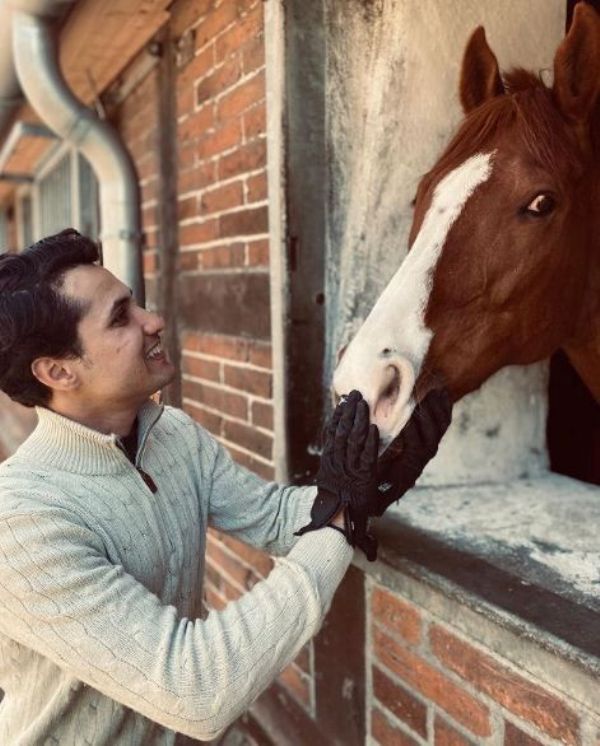 Fouaad Mirza petting his horse Seigneur Medicottedicott
