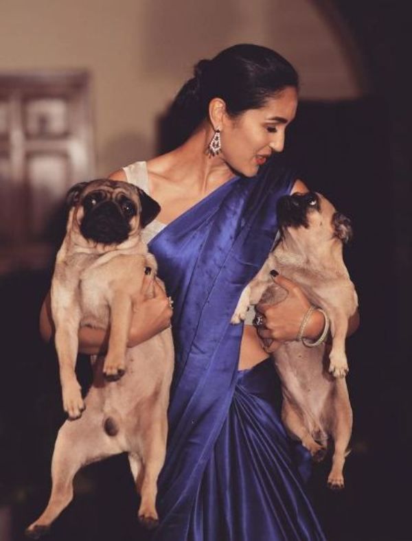 Mira Sethi holding two pug dogs
