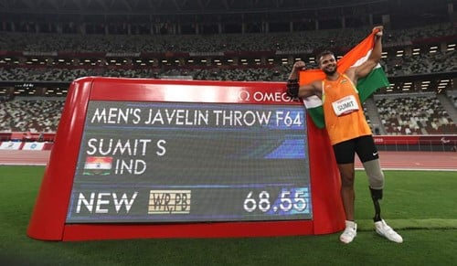 Sumit Antil posing with the scoreboard
