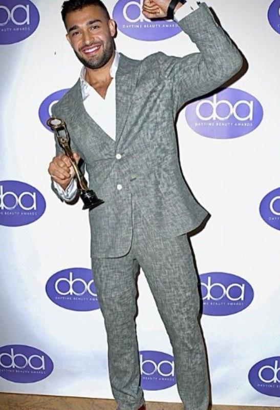 Sam Asghari posing with his Hollywood Beauty Award