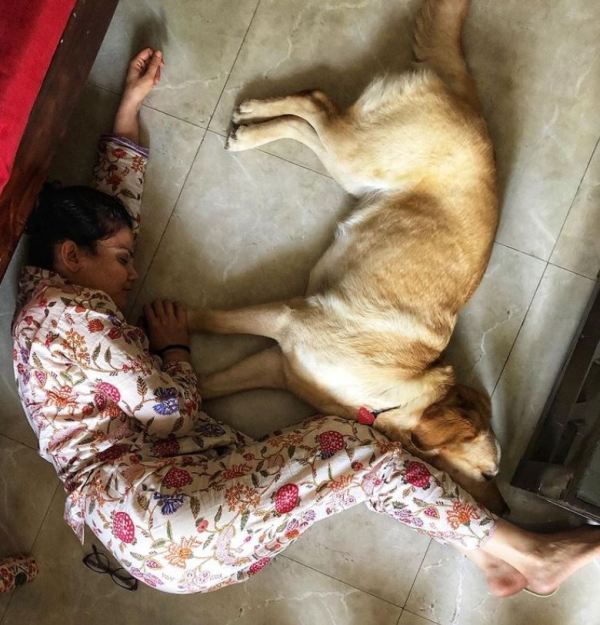Vasudha Rai lying on the floor with her pet dog