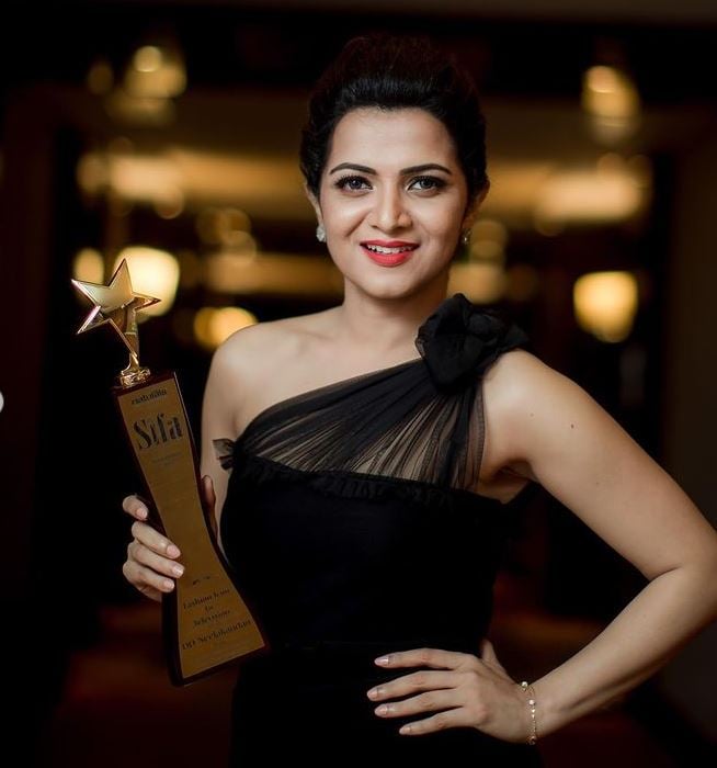 Dhivyadharshini posing with her Sifa Award