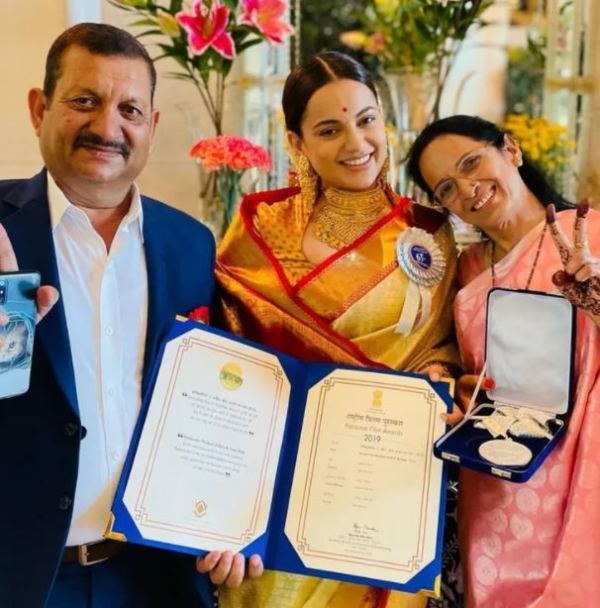 Kangana Ranaut posing with her National Film Award along with her parents