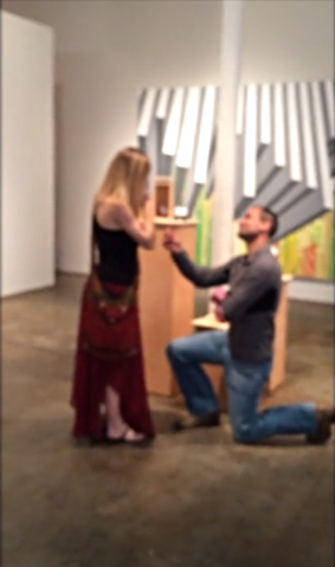 A blurred picture of Anil Menon on his knees while proposing Anna