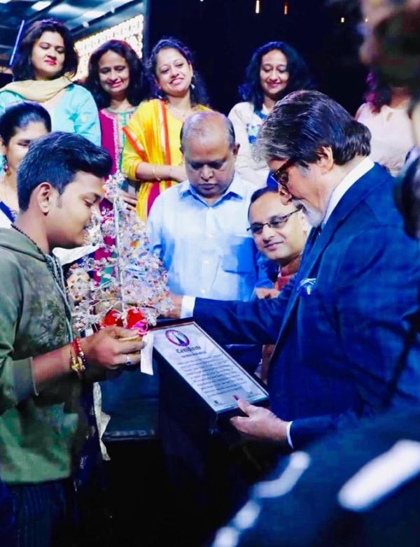 Ayush Gupta on the sets of KBC while posing with Amitabh Bachchan