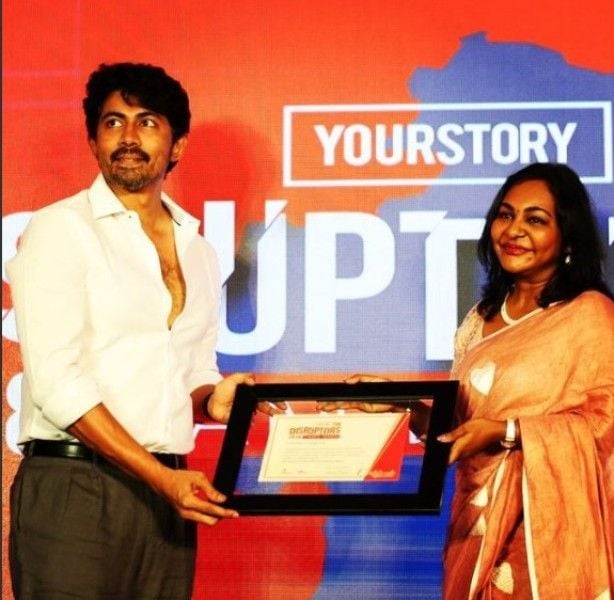 Karthik receiving an award by Your Story