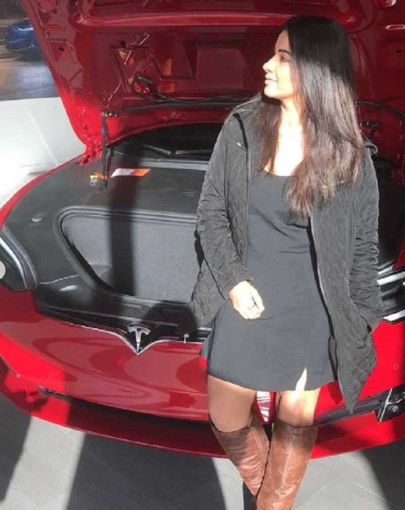 Meetii on her red Tesla car