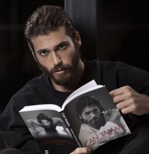 Can Yaman holding his autobiography book