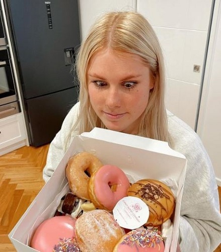 Brooke Warne holding a box of donuts