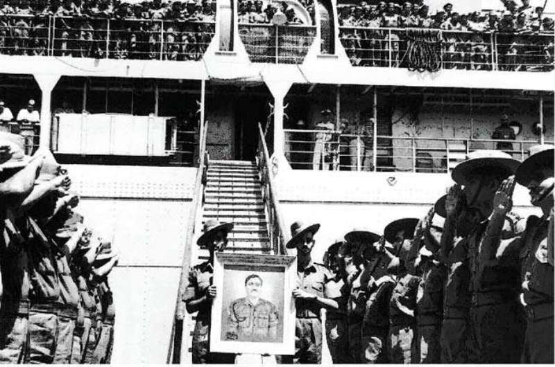 Soldiers carrying the portrait of Captain Salaria as they return from Congo