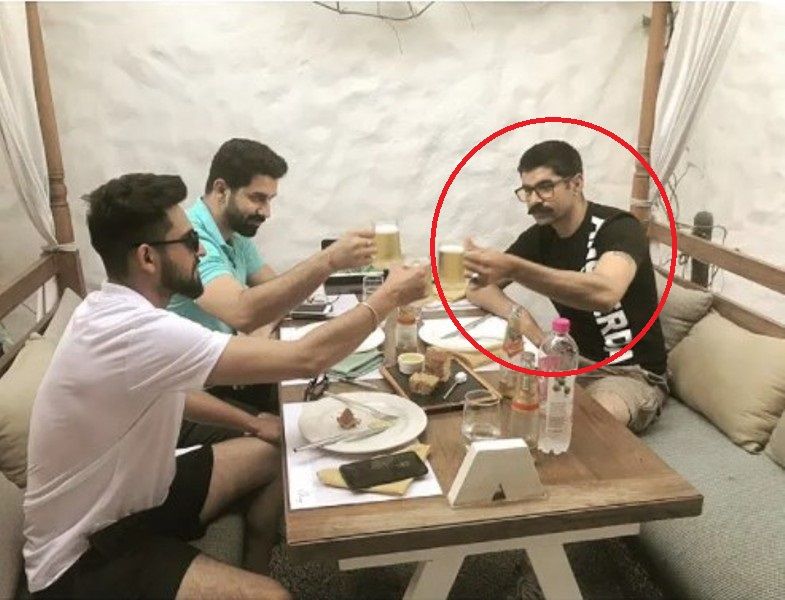 Surya Sharma holding a mug of beer