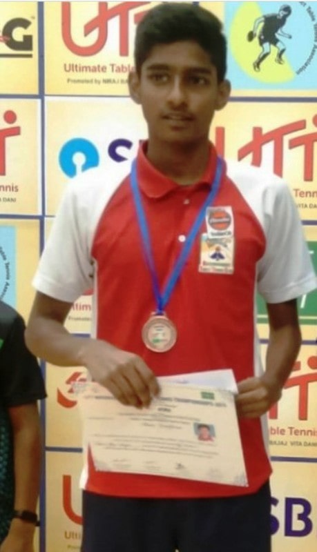 Vishwa with a certificate and a medal after winning a championship