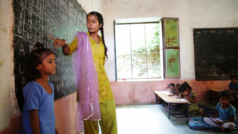 A volunteer to educate girls teaching in a rural village school