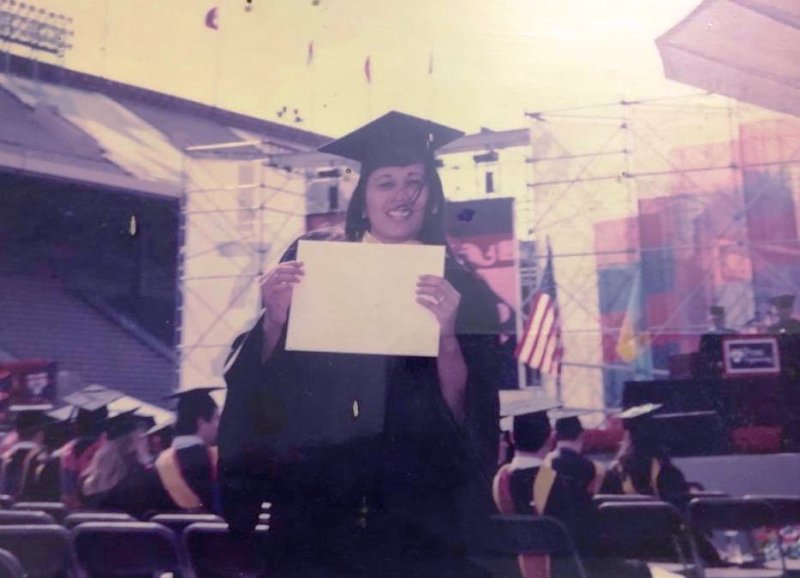 A photograph of Radhika Gupta holding her graduation degree after graduating from the Wharton School