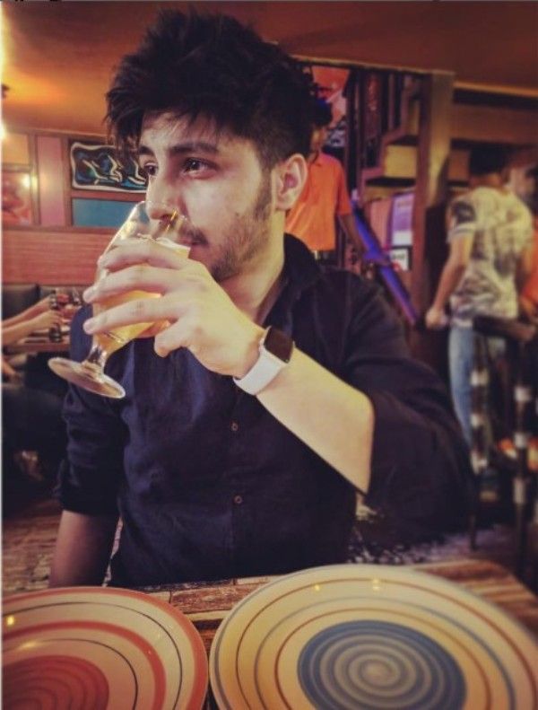 Arjun Harjai holding a glass of beer