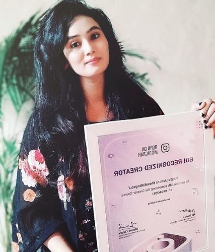 Ritika Singh holding her recognition certificate