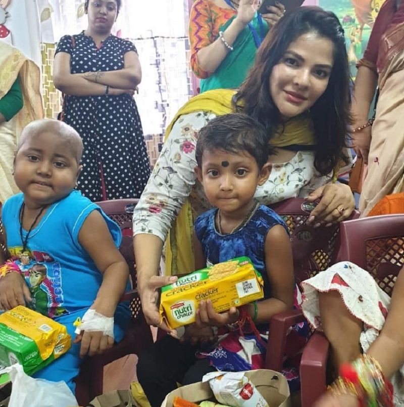 Arpita Mukherjee distributing biscuits in an orphanage