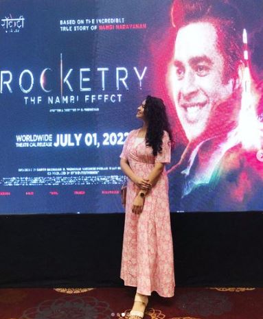 Misha Ghoshal standing in front of the poster of the film Rocketry The Nambi Effect