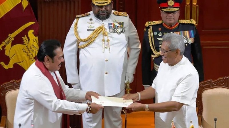 Gotabaya (right) accepting a document from Mahinda (left) during Mahinda's oath-taking ceremony as the Prime Minister