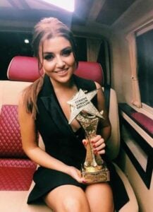 Hande Erçel posing with her Best Actress Award for the television show Güneşin Kızları