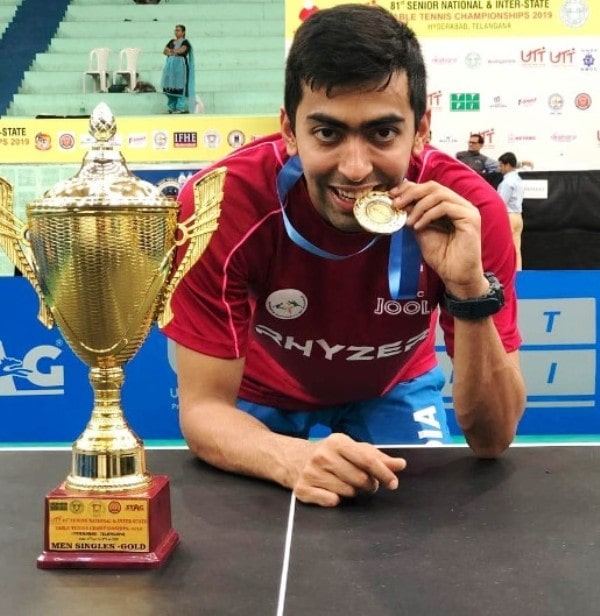Harmeet Desai displaying his gold medal and a trophy after winning the 81st National Table Tennis Championship