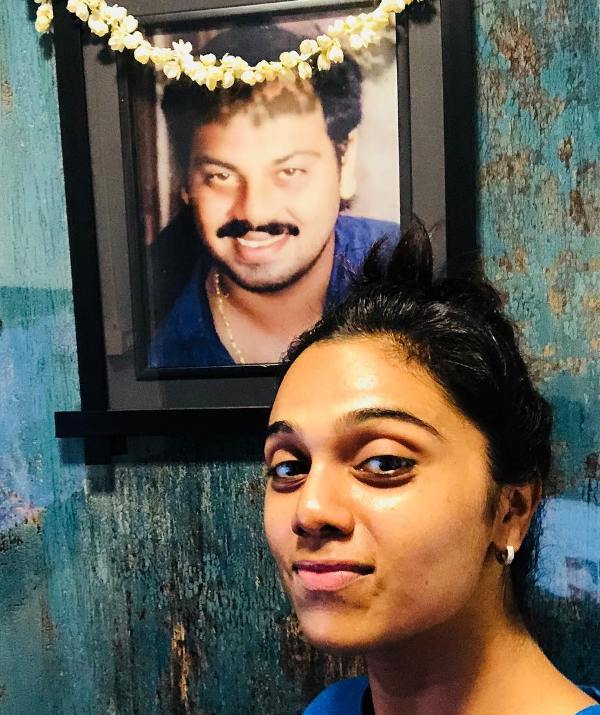 Abhinayashree posing with a picture of her father
