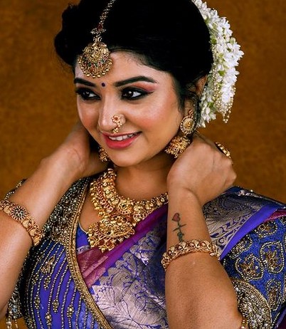 Mahalakshmi featuring a tattoo on her left arm