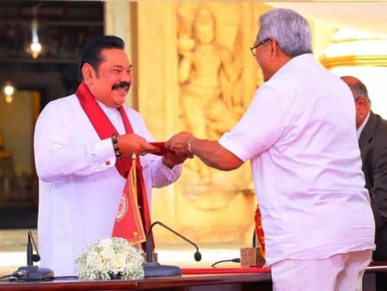 Mahinda Rajapaksa (left) handing over documents to Gotabaya Rajapaksa after taking oath as the Prime Minister of Sri Lanka