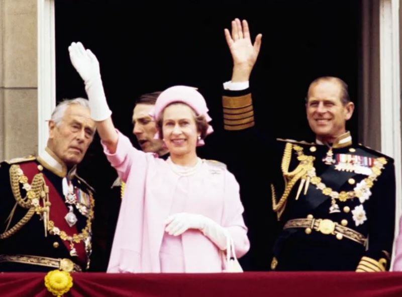 Queen Elizabeth II and Prince Philip waving from the balcony of Buckingham Palace after the Silver Jubilee procession on July 6, 1977