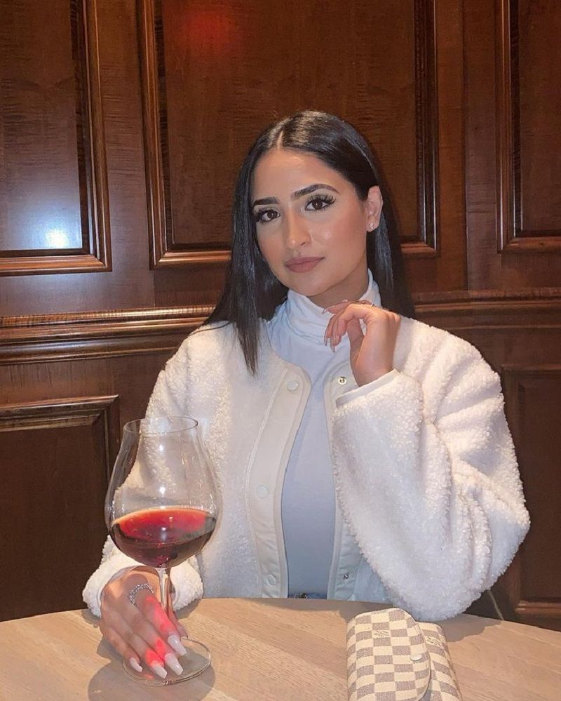 Tanu Grewal holding a glass of wine