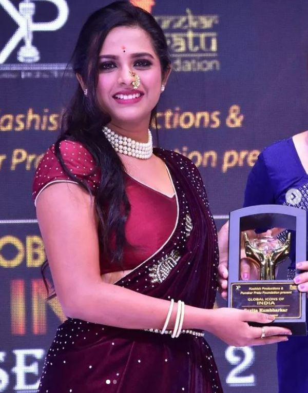 Amruta Dhongade holding the Global Icon of India award (2021)