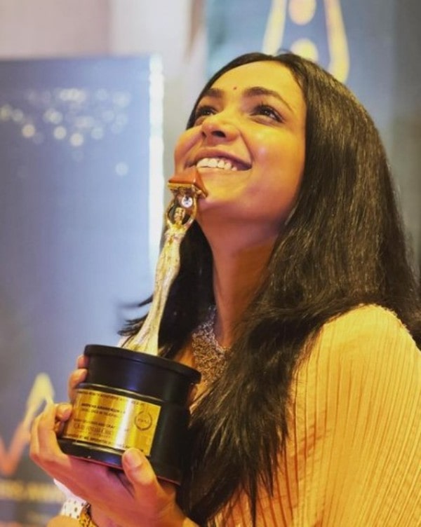 Anupama Gowda holding her KWAA award