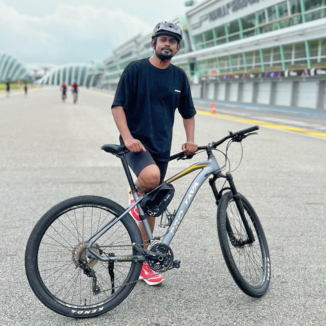Dinesh Kanagaratnam standing next to his cycle