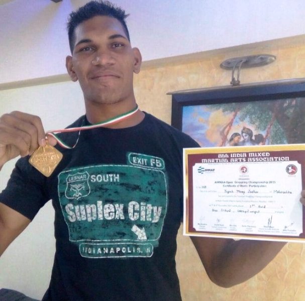 Yogesh Jadhav holds his gold medal which he won at the National MMA Championship