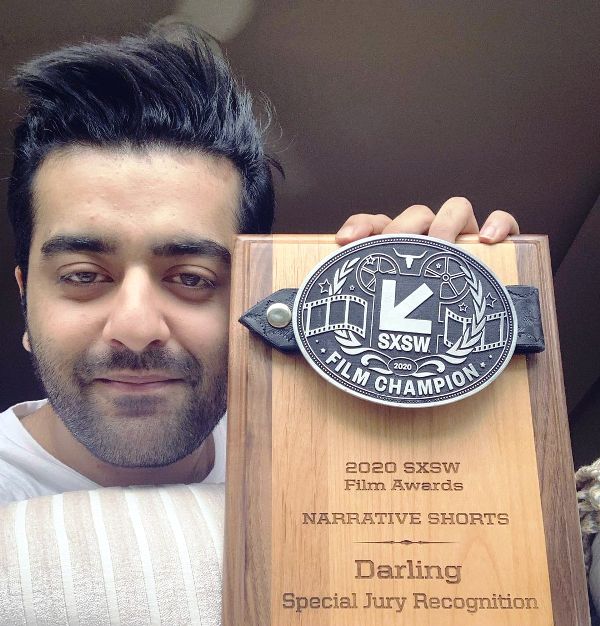 A photo of Saim Sadiq with the SXSW award that his directed short film Darling received